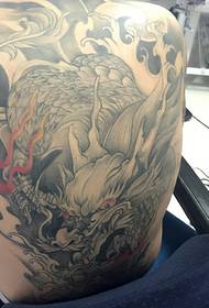 Črno-bela slika velikega zmaja za tetovažo, ki pokriva celoten hrbet