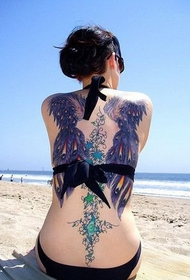 Задній квітка бікіні краси з татуюванням на крилах