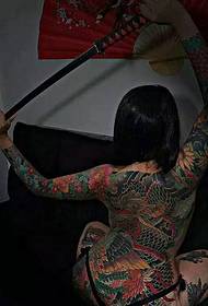 Ragazza giapponese piena di tradizionali immagini del tatuaggio del drago malvagio