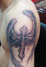 arm med en bevingad kors tatuering