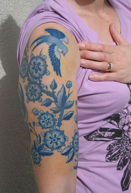 vrouwelijke grote arm op blauwe en witte kleur tattoo