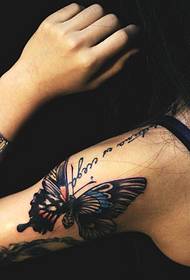 mergaitės ranka ant keistos drugelio tatuiruotės