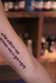 Tattoo sanskrit ayaa lagu arkay gacanta gudaheeda