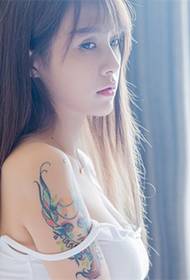 Секси убавица ја покажува модната тетоважа со рака