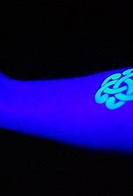 glänzendes fluoreszierendes Tattoo am Arm