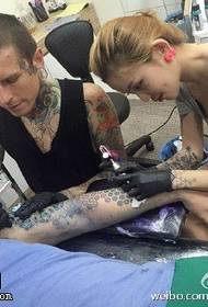 Уметник за тетоважа за време на операцијата за тетоважа