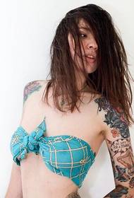 Boireannach tattooed sexy le bikini