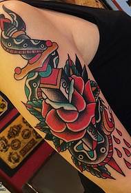 Rose dagger tattoo ntawm caj npab