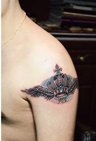 Pearsantacht faisean lámh fireann ag féachaint ar sciatháin choróin pictiúir tattoo