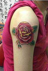 Piękne ramię na czerwonym obrazku tatuażu czerwonej drobnej róży