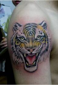 Immagine di tatuaggio di testa di tigre di colore bello e prepotente del braccio maschile di personalità