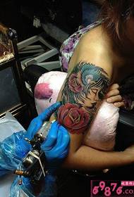 Ang arm na babae na may rose tattoo pattern live na larawan