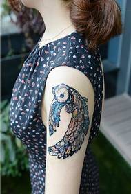 Снимка на женска ръка красива цветна татуировка на сова
