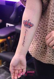 Ferskt engelsk tatoveringsbilde med liten krone arm