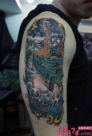 Gambar tato lengan berlayar paus yang mendominasi