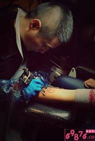 Imagem de processo de operação de tatuagem de lótus de tinta de braço