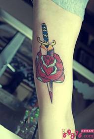 Foto di tatuaggio con pugnale con spina rosa e braccio