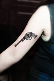 Kreativna slika modne tetovaže revolvera na rukama