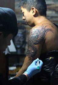 Processo del tatuaggio del fenice braccio braccio tatuatore
