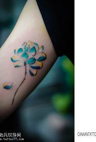 Ženska ruka unutar obojanog uzorka tetovaže lotosa