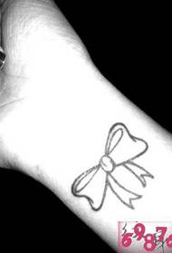 Girl arm black and white bow tattoo