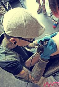 Handsome tattoo msanii wa mkono wa tattoo eneo la tukio