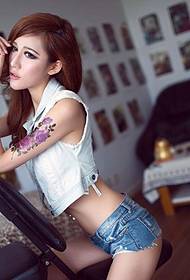 Piękna kobieta kusząca zdjęcie z tatuażem dużego kwiatu na ramieniu