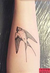 Tatuaggio con rondine al braccio