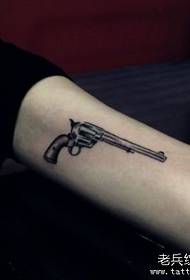 Mergaitė ginkluoja mažą pistoleto tatuiruotės modelį