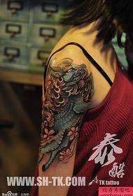Sievietes rokas zils vienradža tetovējums