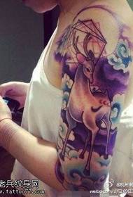 Wanita bekerja lengan tato antelope berbintang berwarna
