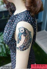 Vrouw arm gekleurde uil tattoo werk