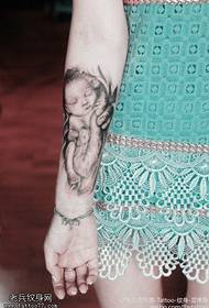 Uma mão de braço muito amorosa segurando uma foto de tatuagem de criança