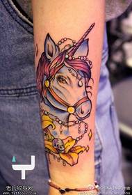 Enfärgade tatueringar i armfärg delas av tatueringar
