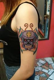 Il tatuaggio della farfalla del cranio del braccio della donna funziona dallo spettacolo di figure di tatuaggio