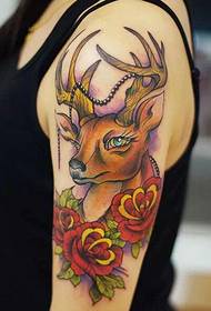 Cerf de bras de femme avec des travaux de tatouage rose