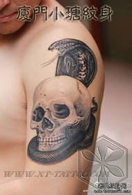 Hombre brazo guapo cobra con patrón de tatuaje de calavera