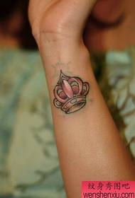 Tetovējumu šovu joslā ieteica sievietes rokas vainaga tetovējuma modeli