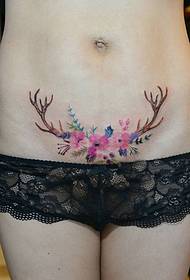abdomen tattoo covering the scared horns flowers
