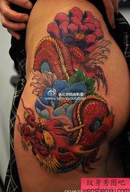 egy gyönyörű nő csípőjét uralkodó sárkány tetoválás mintával