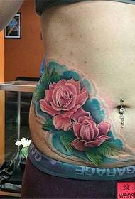 modello di tatuaggio rosa colorato addome di una donna