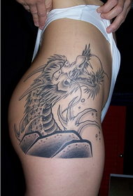 жена показује узорак змаја за тетоважу кука
