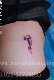 una nena a les natges d'un bonic patró de tatuatges de lletres de serps