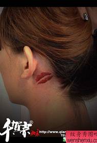 det populära läppstatuerade tatueringsmönstret på flickans hals