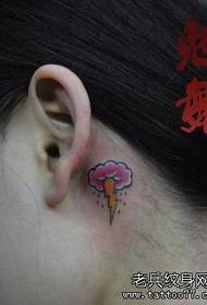 melns mākonis un mazs zibens tetovējuma raksts uz meitenes auss