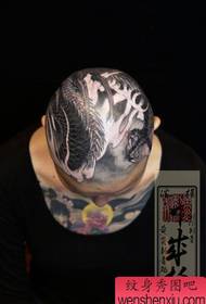 moabut ang ulo sa usa ka batang babaye nga tradisyonal nga sumbanan sa tattoo sa dragon