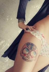 gamba destra della ragazza sul cuore e motivo del tatuaggio del cranio