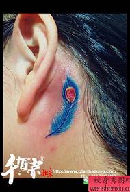 un piccolo tatuaggio con piume per orecchie femminili