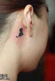 un piccolo tatuaggio del gatto nero dietro l'orecchio