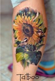 Piernas de magníficos colores realistas girasoles y pequeño tatuaje de pájaro